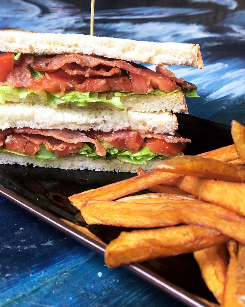 A BLT Sandwich on a plate with homemade french fries